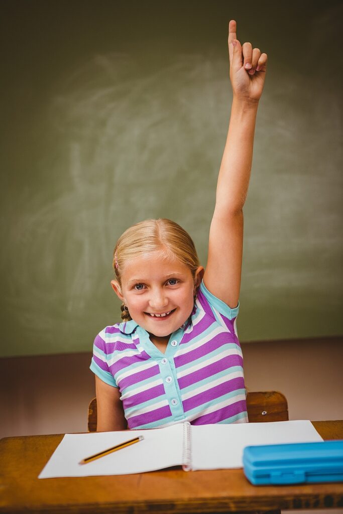 Image of eager student with hand up waiting to ask the teacher a question!