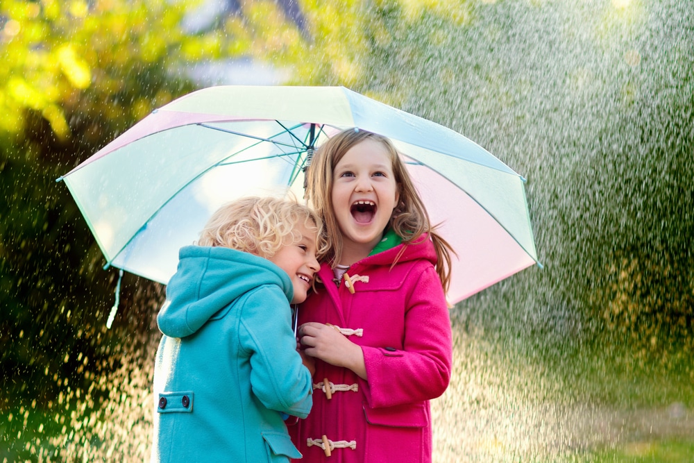 Image of kids with umbrella in the rain with fun weather activities.
